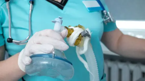 Getty Images Nurse with oxygen mask