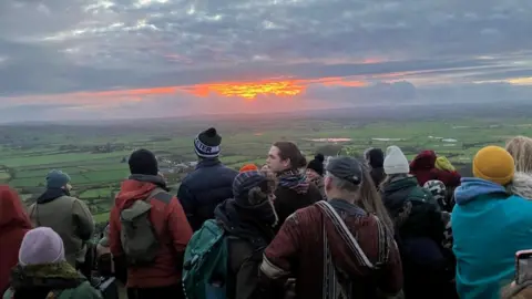 People celebrating winter solstice at Glastonbury Tor