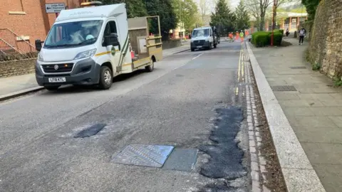 BBC/Martin Heath Black patches show where holes have been filled on a road