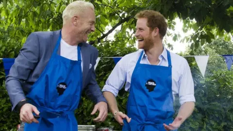 Heads Together Iwan Thomas and Prince Harry at Heads Together event at Kensington Palace - cooking burgers