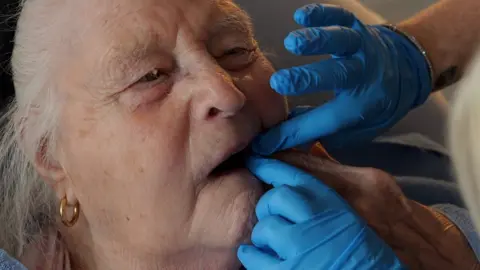 Female resident having her teeth checked