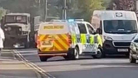 Military truck being driven towards a police car