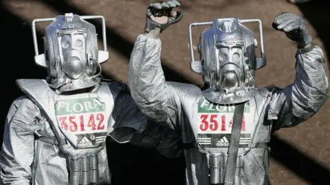 Getty Images Fun runners dressed as Cybermen celebrate after crossing the finish line during the 2005 London Marathon