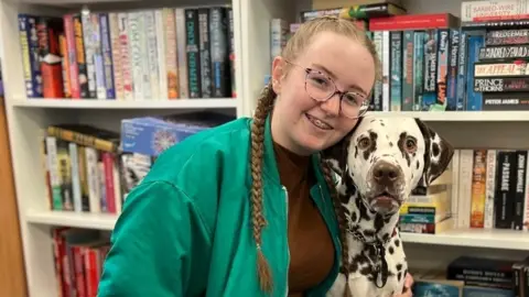 Teenager girl and dalmatian dog in library