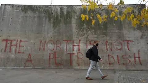 Getty Images Man in front of sign saying the North is not a petri dish