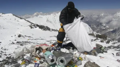 Getty Images Nepalese sherpa picking up trash on Everest