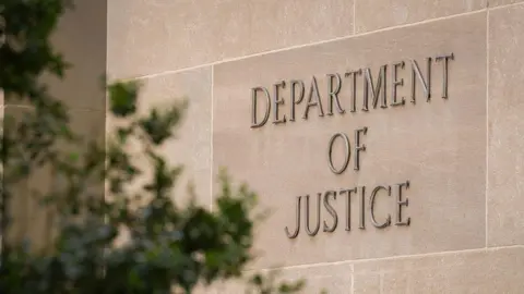 Getty Images A sign marks the location of the U.S. Department of Justice (DOJ) headquarters building