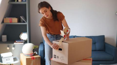 Woman packing up boxes as she prepares to move house