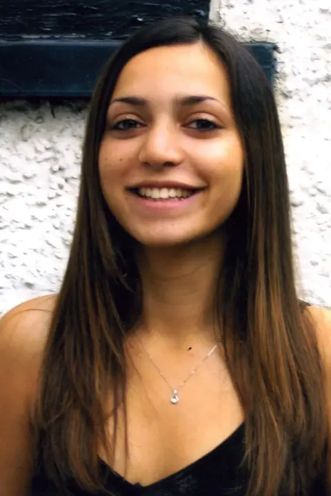 PA Media Meredith Kercher. She has long brown hair and is wearing a black dress, smiling at the camera.