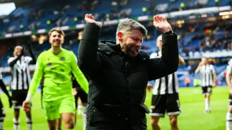 St Mirren manager Stephen Robinson celebrates with fans after a win at Ibrox