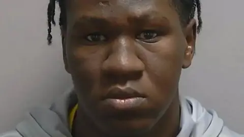 Hampshire Constabulary A close up picture of Sudanese man's face posing for a police mug shot.