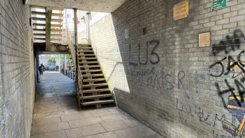 Ben Schofield/BBC An alley way leading away from a parade of shops in Sundon Park, Luton