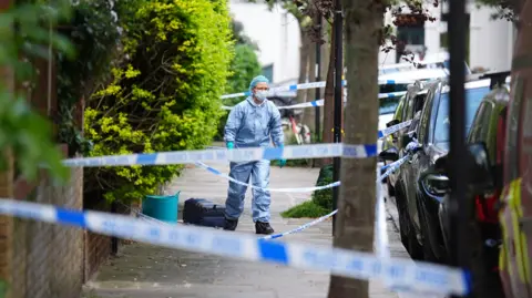 A forensics officer is seen in Kentish Town, north London where police investigated a fire at Sir Keir Starmer's house in north London