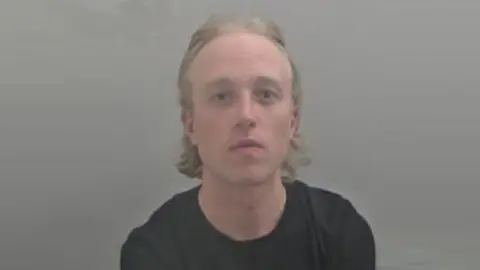 West Mercia Police A police headshot of a man with blond hair who is looking at the camera. 