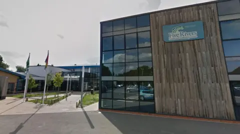 Google Maps The entrance and side of Five Rivers leisure centre in Salisbury, which has dark grey wood panelling on the side.