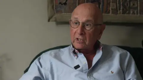 Ian Collier in a blue shirt.