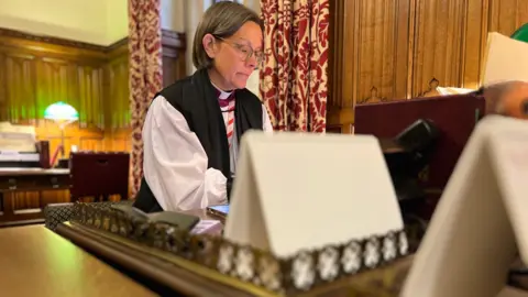 BBC/Richard Moss Bishop of Newcastle Helen Ann Hartley sits at her desk in Westminster, wearing her clergy clothing.