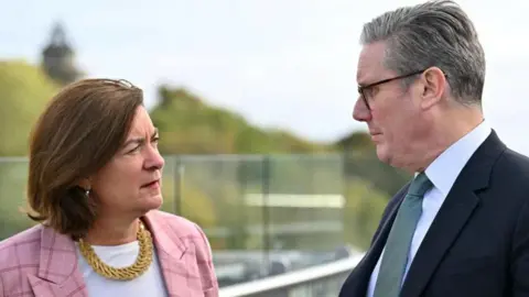 Reuters Eluned Morgan and Sir Keir Starmer standing looking at each other at Queen Elizabeth House in Edinburgh.