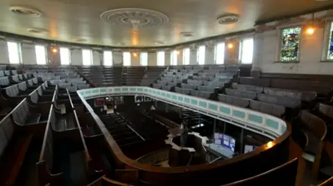 BBC Inside view from upstairs in the chapel showing brown seats in a circular formation