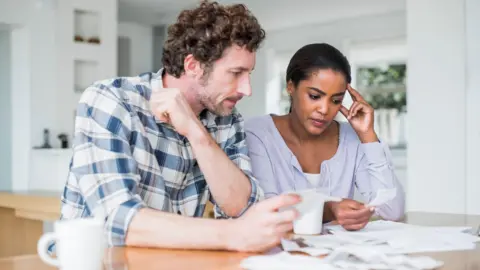 Couple sitting at table looking at bills