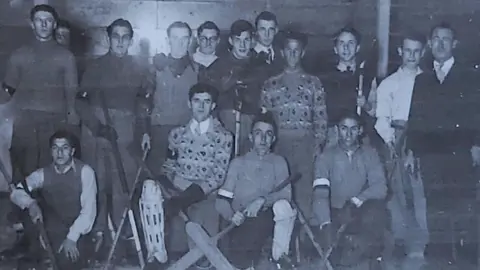 Supplied Russ Proudfoot, second at the back, from left to right, is standing with a hockey stick surrounded by Durham Wasps players in 1947.