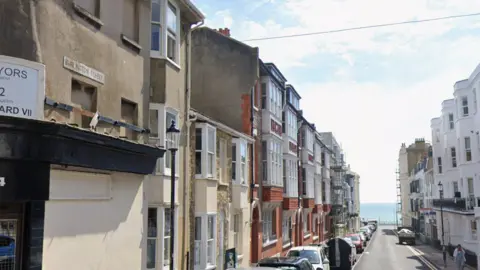 Google A view of Burlington Street in Kemptown, Brighton, a narrow row of three-storey Regency terrace houses leading to the seafront.