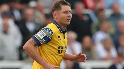 Harry Beautyman jogging on the pitch during a match for Woking this season