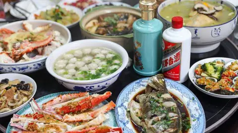 Getty Images A table laid with a lavish array of Chinese food, including fish, vegetables and soups