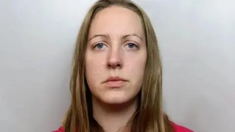 A police mugshot of Lucy Letby, who has straight blonde hair and stares into the camera with a blank expression.