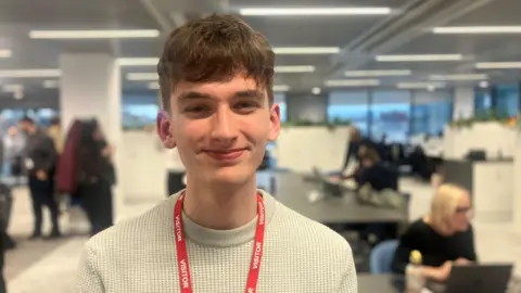 Photograph of sixteen year-old Declan Brooks from Stockport. He is pictured in an office in Manchester city centre.