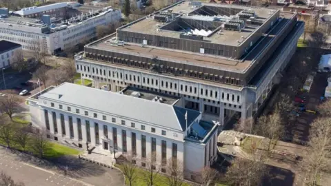 Getty Images An aerial view of the Welsh government building in Cathays Park, Cardiff. It is made up of two buildings, with the one in the front appearing to be a quarter of the size of the one behind it.