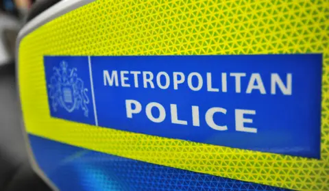 Close-up image of the Metropolitan Police logo, which has white lettering on a blue background and yellow border.
