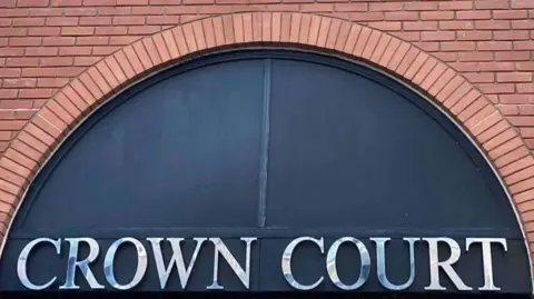 St Albans Crown Court: The words "CROWN COURT" written in silver on a blue semi-circular background.