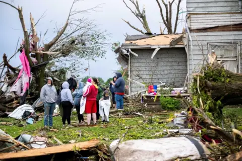 Reuters People gather to assess the damage as debris surrounds them