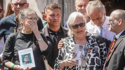 PA Media Families outside Central Hall in Westminster, London, after the publication of the Infected Blood Inquiry report