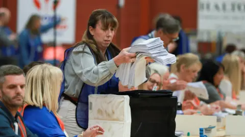 Votes are taken out of a ballot box for counting on the day of the Runcorn and Helsby by-election