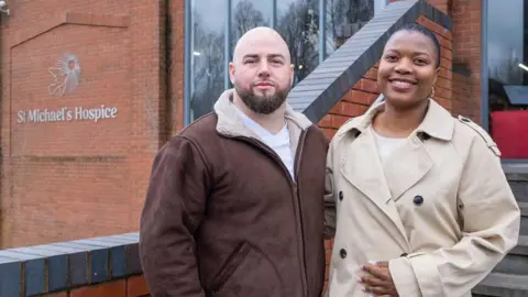 Ryan and Miley stand outside a St Michael's Hospice building.