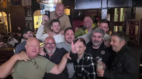 Steve Bruce A group of middle-aged men at a pub, some carrying pints of Guinness and looking merry