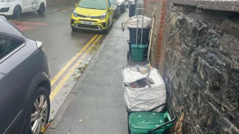 A street with piles of bins 