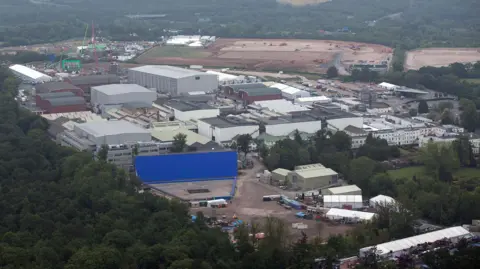 Getty Images An aerial view of Pinewood Studios. We can see several large grey buildings, with forestry in the foreground.