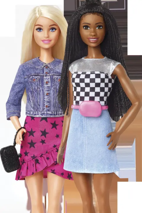 Mattel Inc Two fashion dolls posed side by side against a plain background. One doll wears a denim jacket with a pink skirt patterned with black stars and holds a small black handbag, while the other wears a black-and-white checkered top, a light blue skirt, and a pink belt, with long textured hair styled up at the crown.