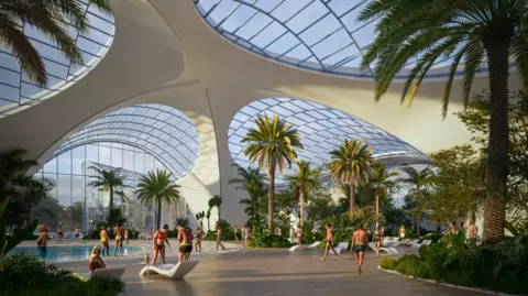 Therme Manchester People in swimming costumes mill in a large foyer under a modern building feature elegant white arches and glass panelled roof. A babbling pool can be seen sheltered by palm trees inside the complex. 