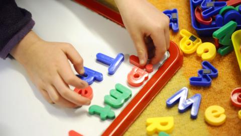 Image of child playing with letter magnets