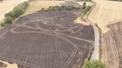 Qays Najm/BBC An aerial picture of a field on Stapletons Lane in Aylsham. The field is charred following a fire.