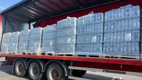 Lili Sheppard/BBC A lorry full of slabs of bottled water.