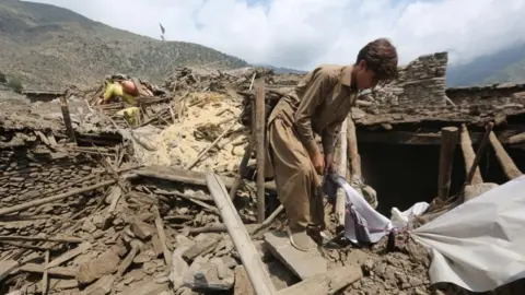 People salvage their belongings from the rubble after an earthquake 