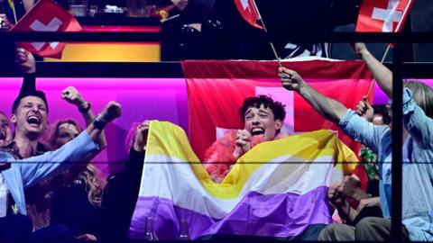 Switzerland's Eurovision winner Nemo and supporters celebrate with non-binary flag