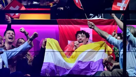 Switzerland's Eurovision winner Nemo and supporters celebrate with non-binary flag