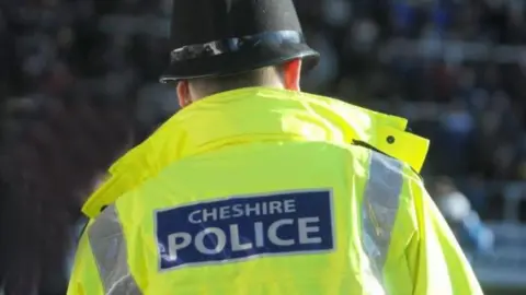 The yellow hi-vis jacket of an anonymous Cheshire Police officer.