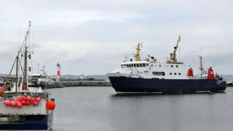 Blue and white ferry approaching a harbour in Orkney.